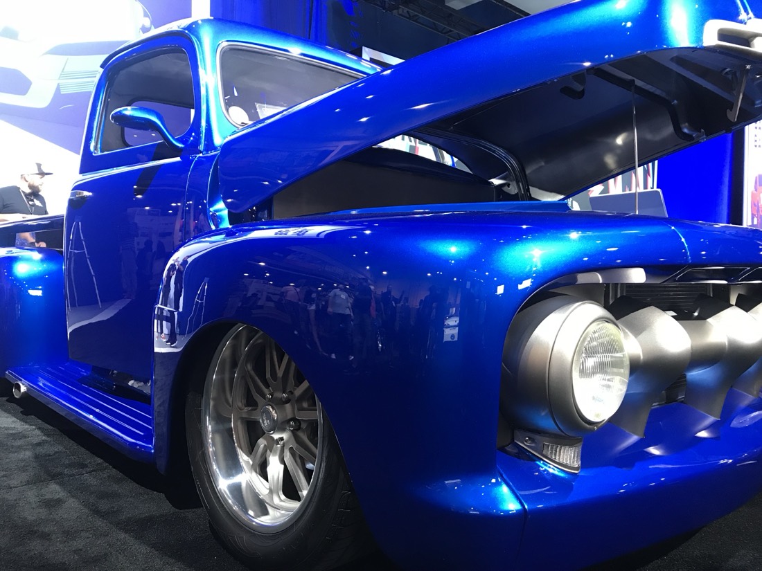 Picape clássica azul com o capô aberto, em exposição no SEMA Show, em Las Vegas